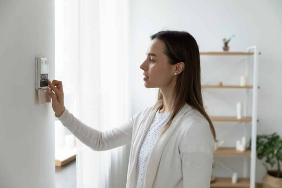 Pleasant young woman using smart home system.